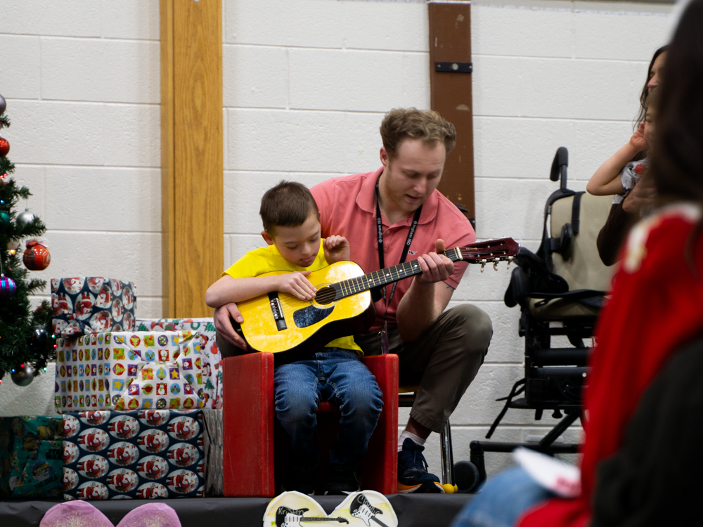 Child sitting in a chair playing the guitar